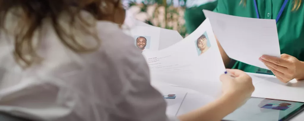 Responsable RH analysant des CV pour illustrer le choix entre recruter ou automatiser en PME