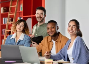 Équipe de professionnels souriants travaillant ensemble sur ordinateur pour constituer une équipe dynamique en entreprise.
