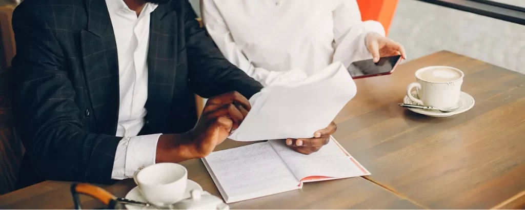 Professionnel analysant des documents de procédures et un cahier de notes pour préparer un onboarding offshore