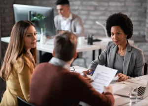 Consultation en stratégie des ressources humaines entre une experte externe et deux collaborateurs d'entreprise.